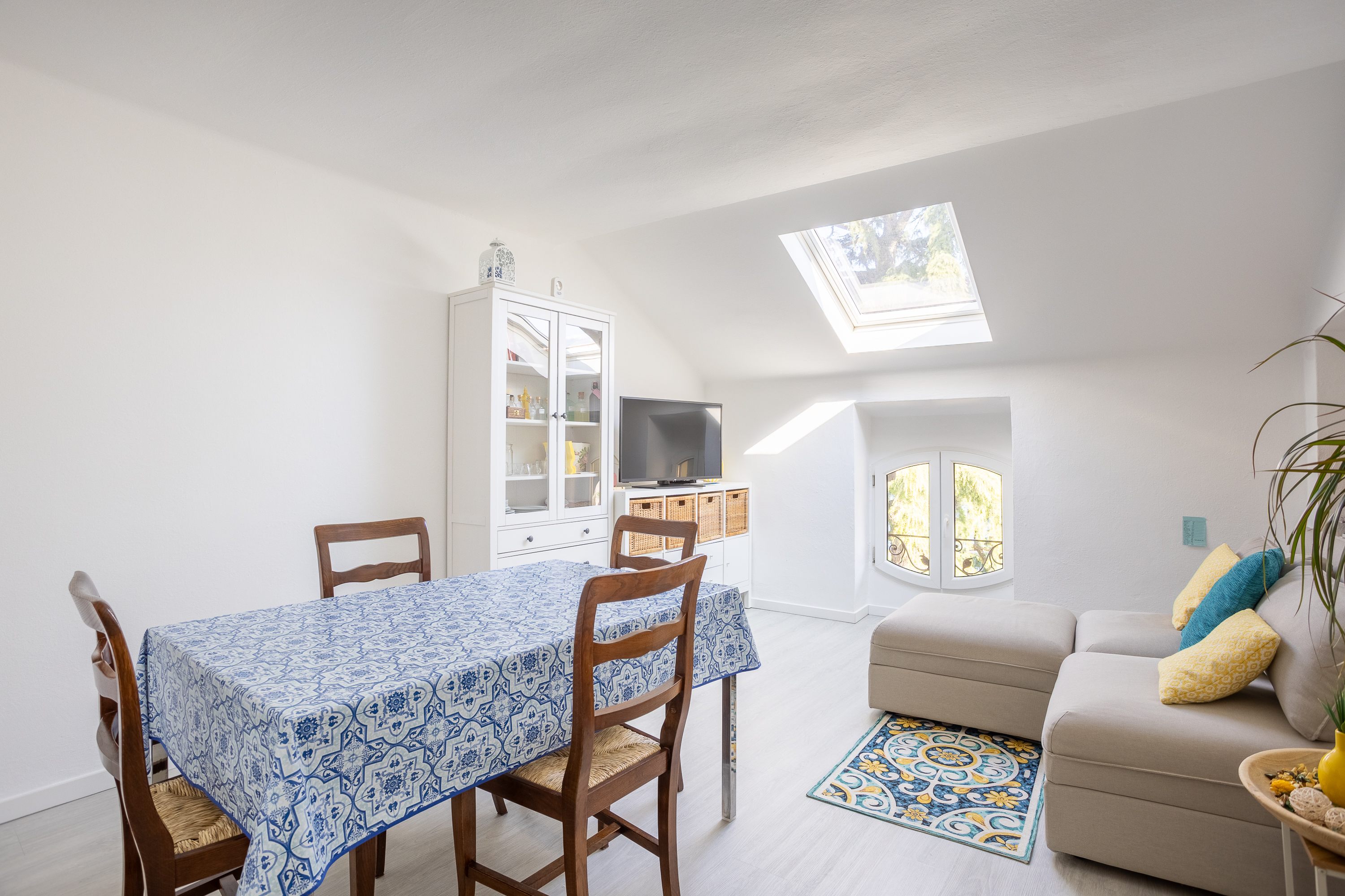 Bright living room with dining table and skylights